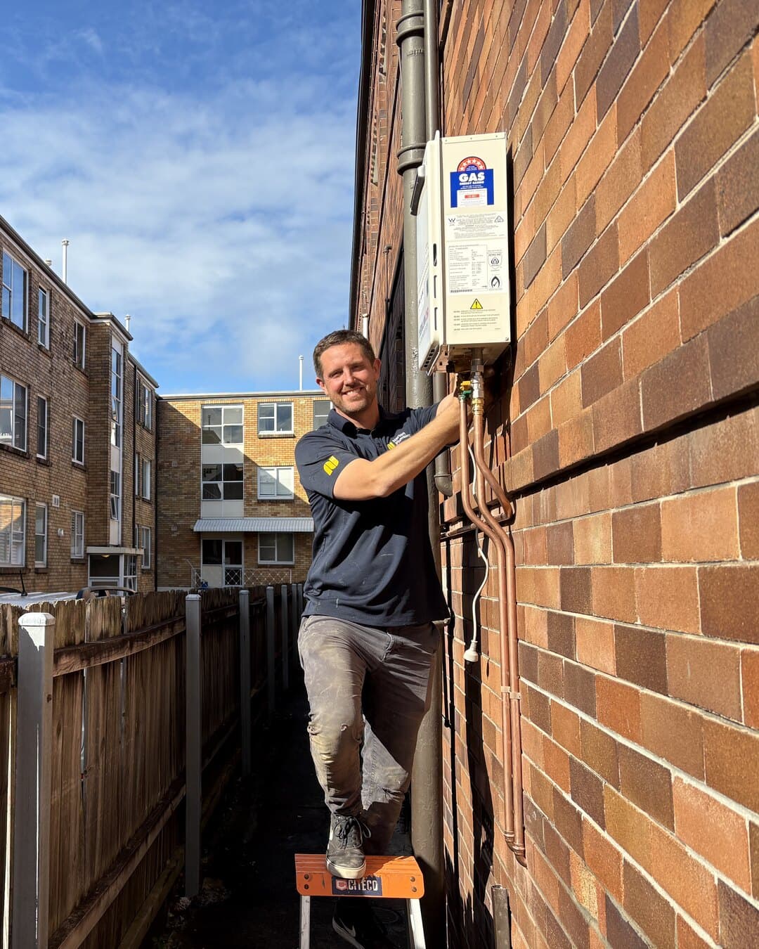 Adam Norton servicing a wall-mounted gas hot water unit at a Byron Street apartment, Eastern Suburbs Sydney