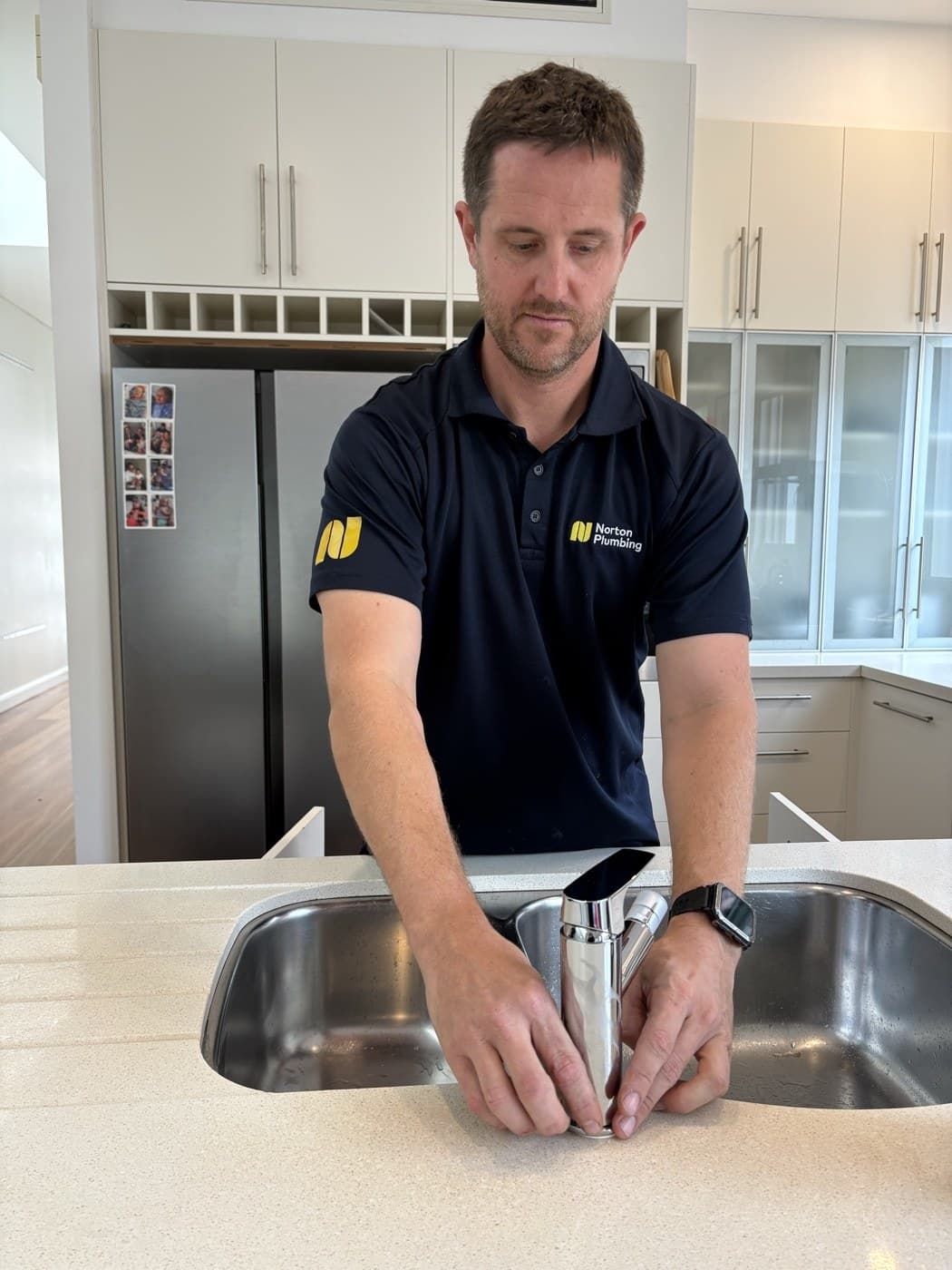 Filtered water flowing from a kitchen tap after Puretec FilterWall install, Adam Norton commissioning the system in Clovelly