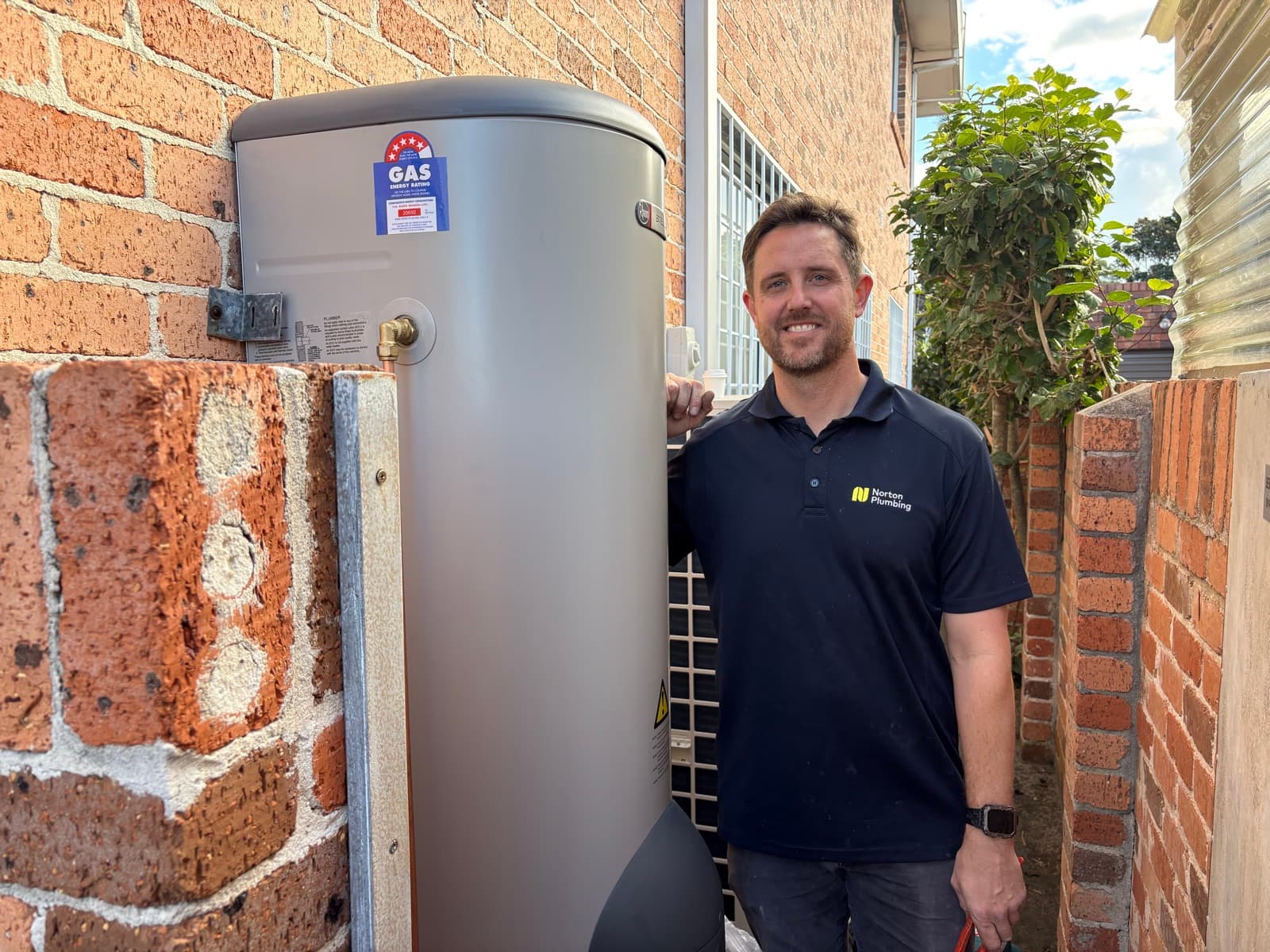 Adam Norton with a newly installed Rheem gas hot water system in Maroubra, Eastern Suburbs Sydney