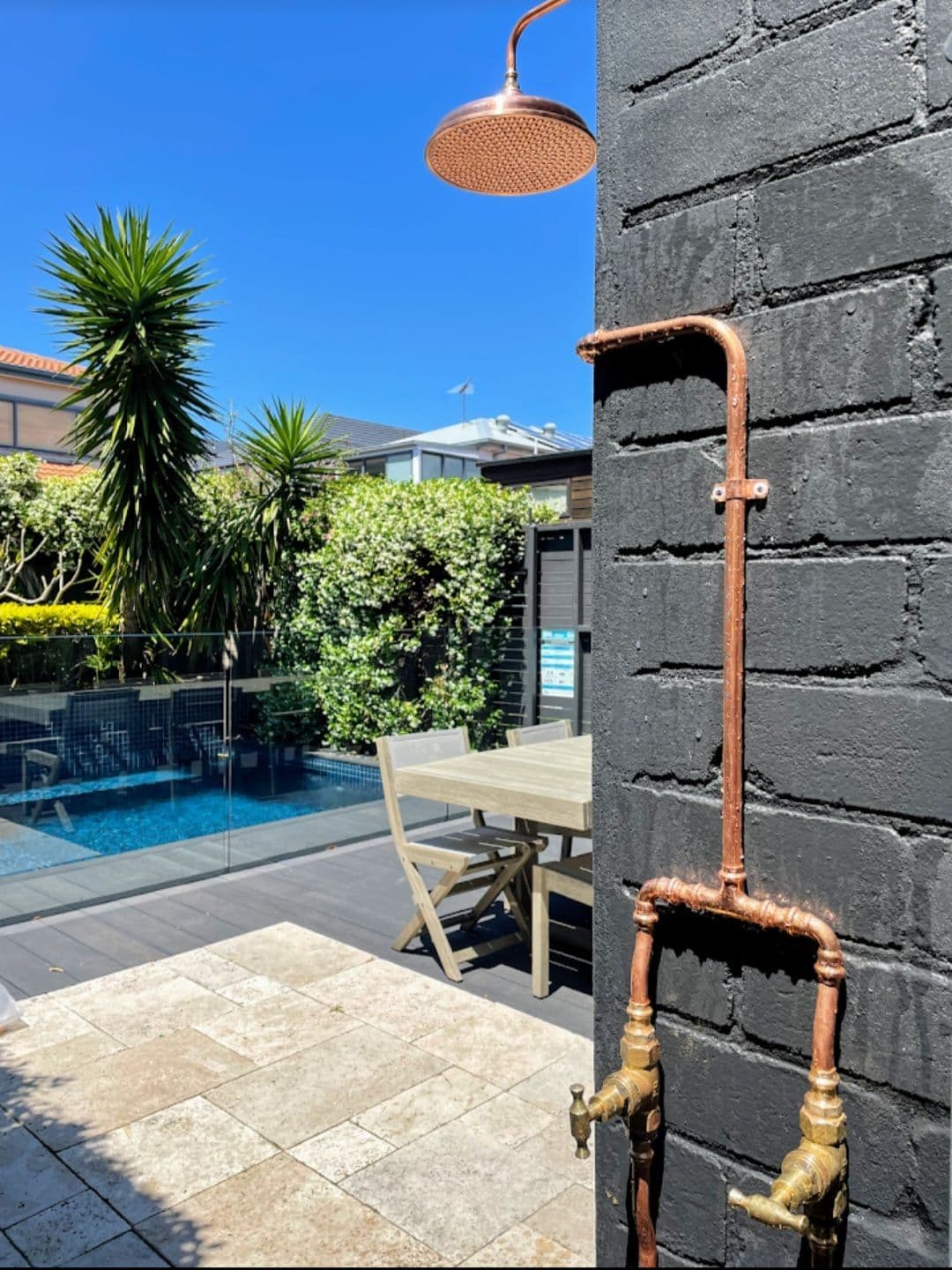 Copper outdoor shower installation with showerhead visible at the top