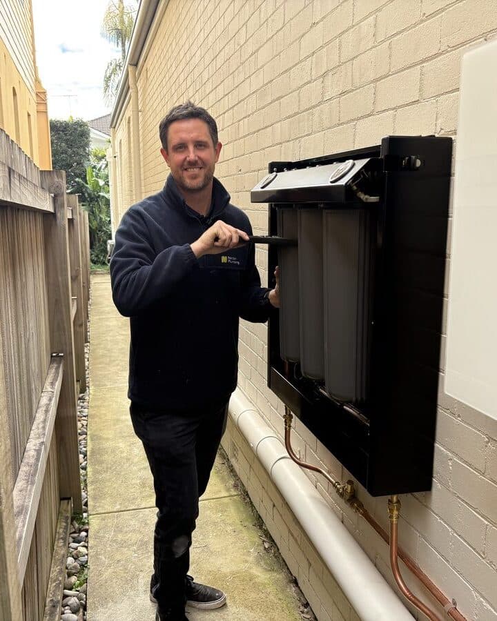 Adam from Norton Plumbing at the open Puretec FilterWall installed at a Bondi home