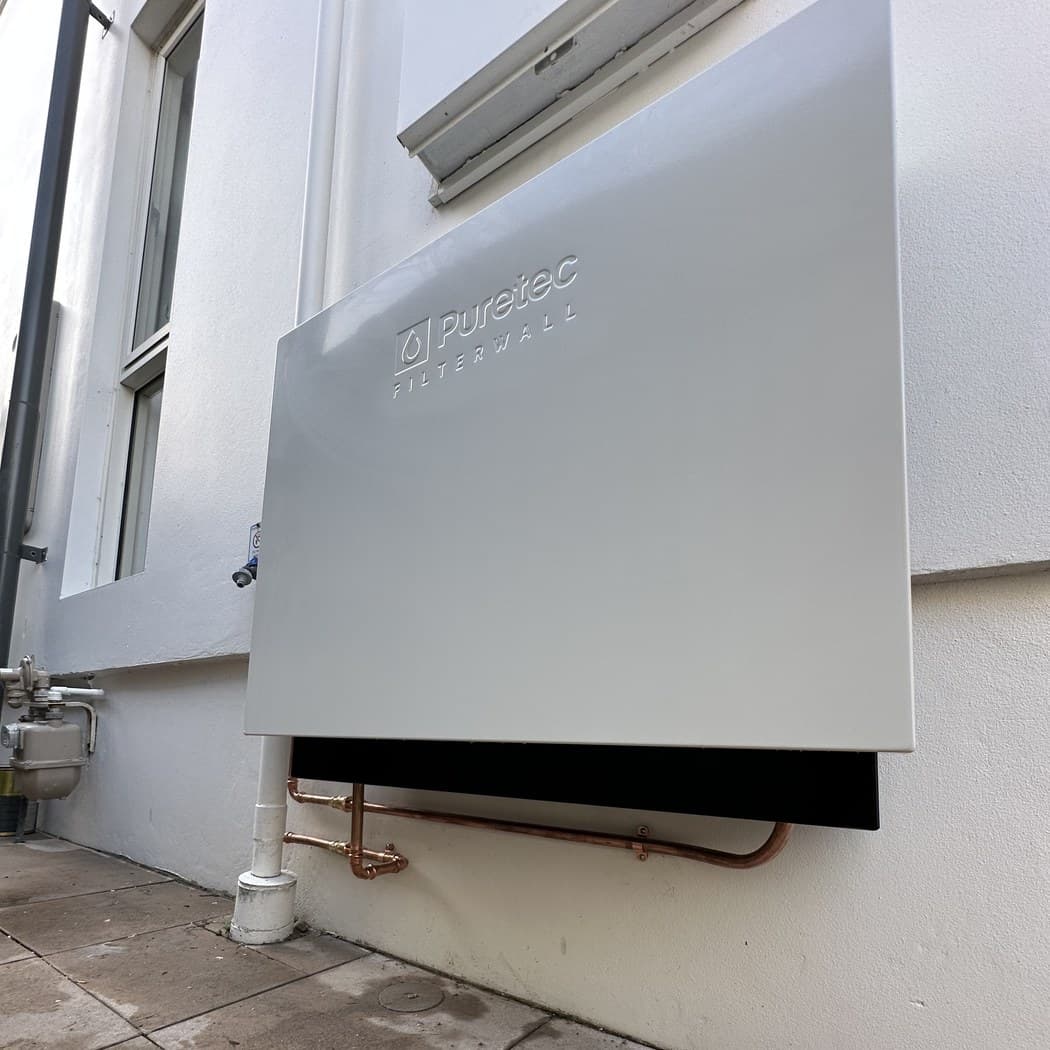 Puretec FilterWall whole-home water filtration system mounted on the side of a Clovelly home, two-stage sediment and carbon filtration