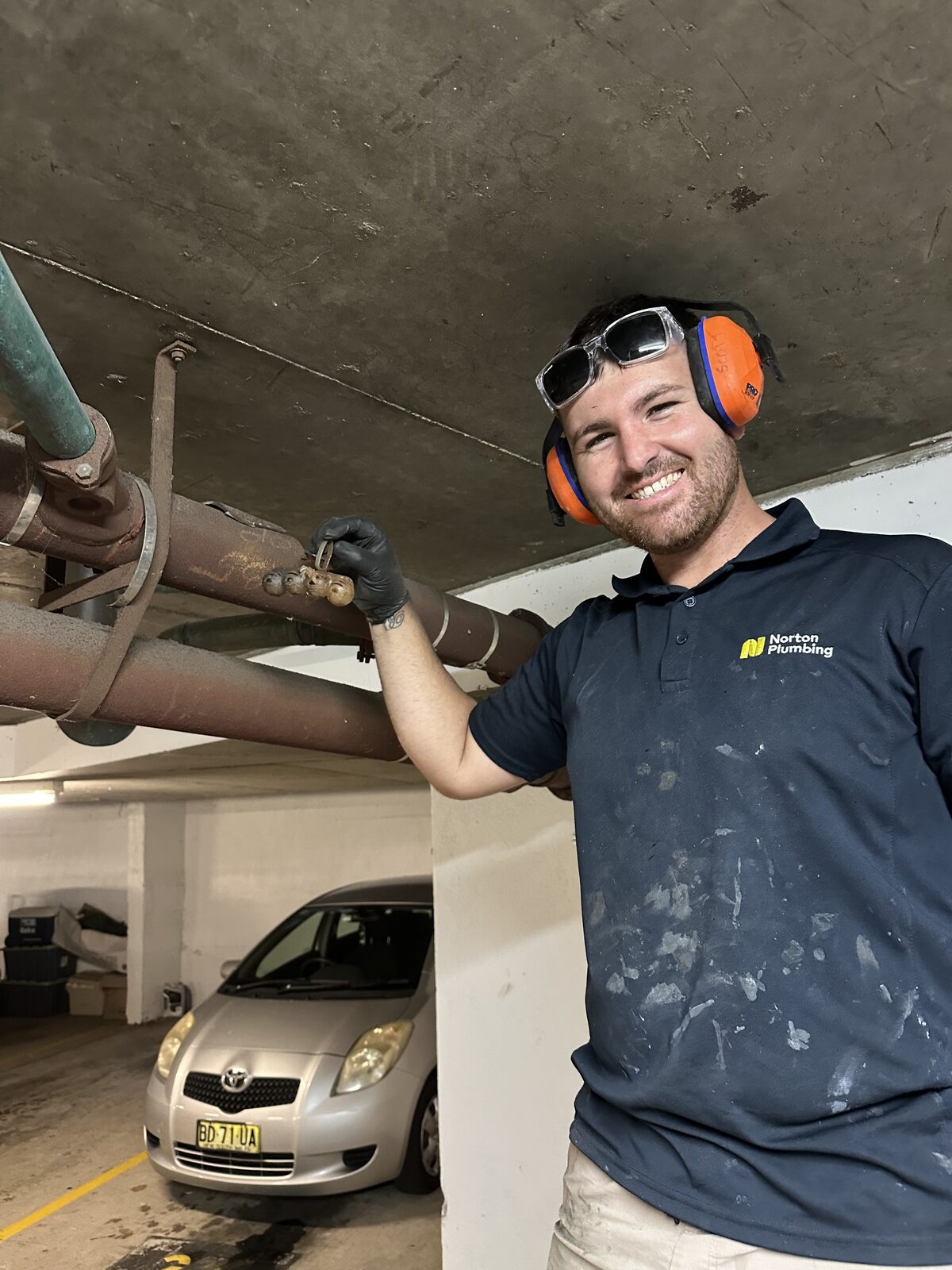 Blake from Norton Plumbing holding a clip-on toilet rim freshener recovered from a blocked drain in a Coogee apartment building