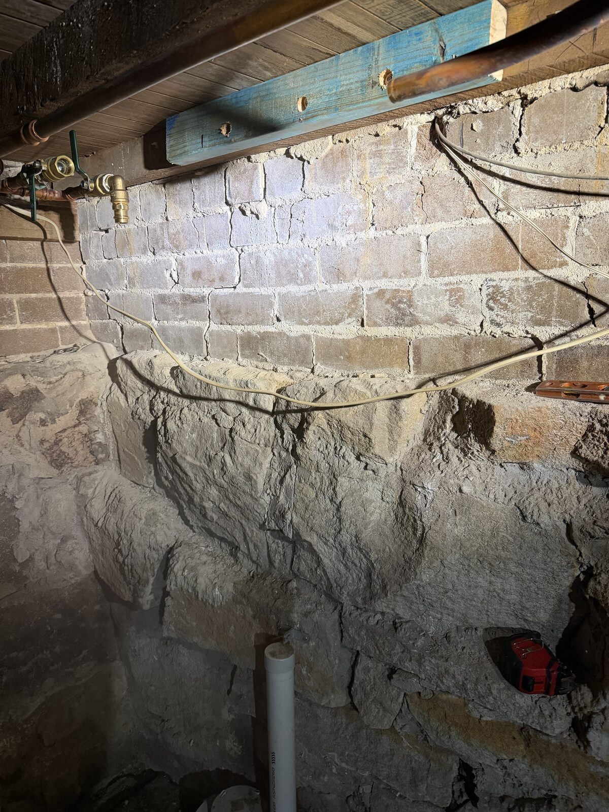 Sandstone basement wall under a North Bondi house with a timber mounting batten fixed in place for a Puretec FilterWall, after the old filter was removed