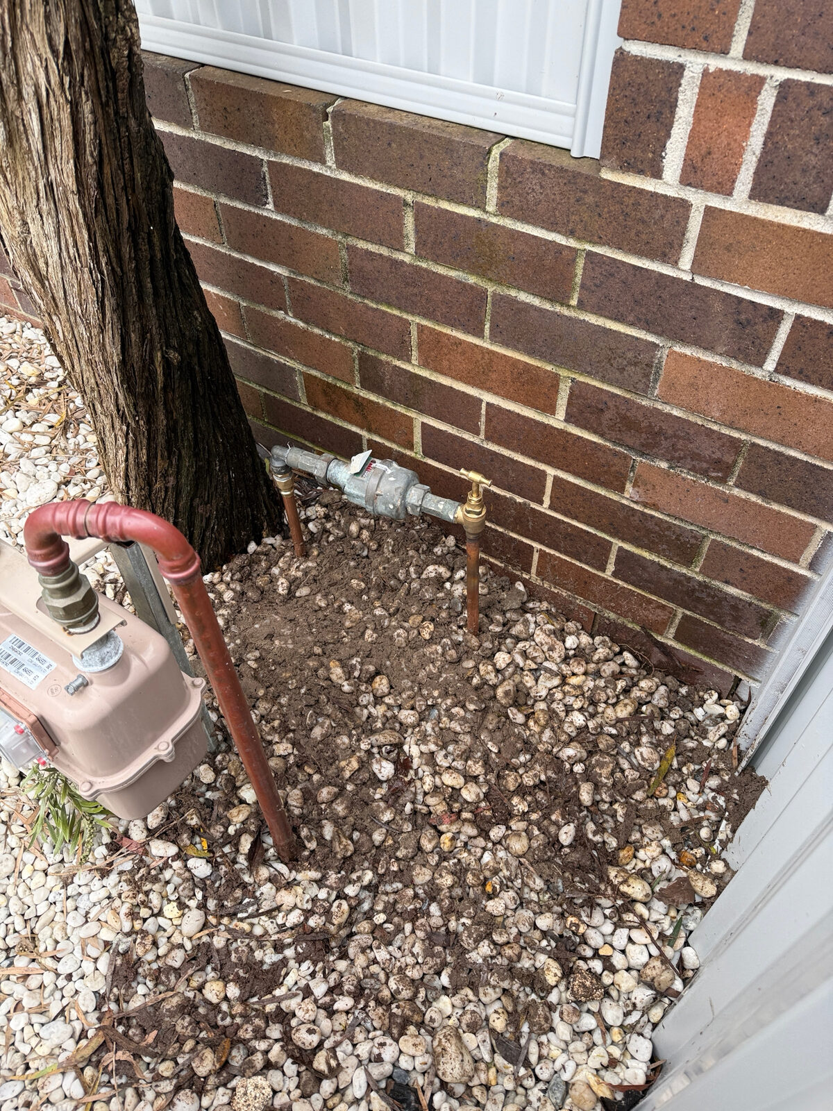 Water meter raised to 300 mm on new copper risers with a new brass meter tap, clear of the garden bed beside the gas meter at a Maroubra house